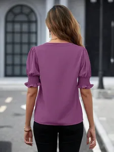 Vista posteriore di elegante camicetta viola con maniche a sbuffo punto smock e volant chic
