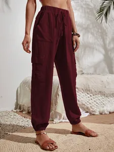 Vista detallada de pantalones cargo burdeos con cintura alta y bolsillos laterales