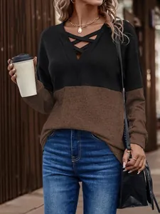Close-up of women's V-neck color-block long sleeve top with criss-cross detail