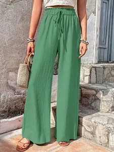 Detail of green bubble grid casual wide-leg trousers with drawstring high waist.