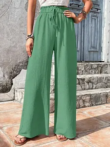 Detailed view of green bubble grid textured wide-leg casual pants for women.
