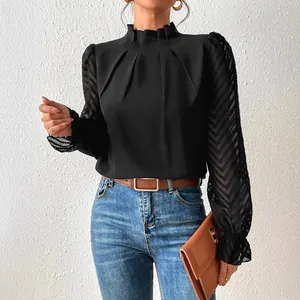 Elegante blusa negra con cuello alto con volantes y mangas abullonadas de gasa