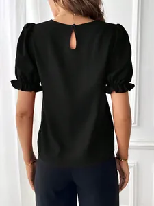 Dettaglio vista posteriore di blusa nera con maniche a sbuffo, apertura a goccia e volant