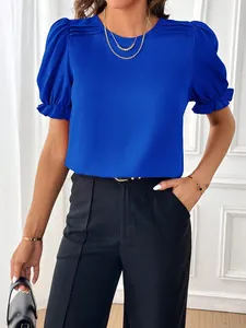 Vista dettagliata di una camicetta blu acceso con scollo rotondo ed eleganti maniche a sbuffo