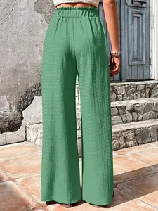 Close-up detail of sage green bubble grid wide-leg pants showing texture and high waist.