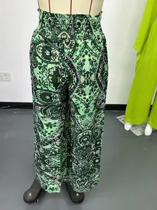 Dettaglio dei pantaloni a gamba larga con stampa paisley verde e vita elasticizzata.