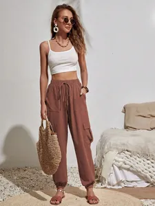 Vista detallada de pantalones cargo marrones de mujer con cintura elástica y bolsillos
