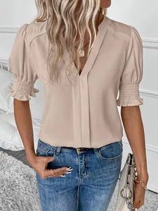 Dettaglio di un'elegante camicetta da donna con scollo a V e maniche a sbuffo in beige
