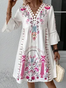 Close-up of white Boho-style dress with V-neck lace patchwork and pink floral print