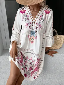 Detailed shot of white floral boho dress featuring intricate lace V-neckline patchwork