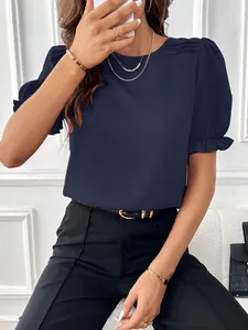 Dettaglio della camicetta blu navy con eleganti maniche a sbuffo e spalle pieghettate