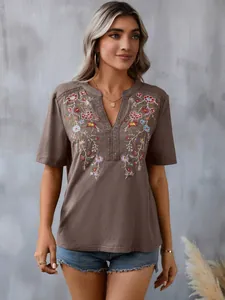 Detailed view of the intricate floral embroidery and lace trim on this boho summer top.