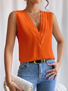 Detailaufnahme des eleganten plissierten mehrlagigen V-Ausschnitts an einem orangefarbenen Top.