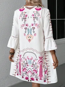 Back view of a white boho floral printed dress with bell sleeves and lace detail