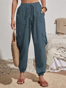 Vista detallada de un pantalón cargo azul para mujer con talle alto y bolsillos laterales.