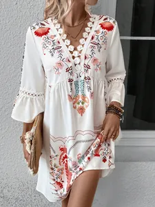 Detailed view of bohemian floral dress with lace V-neck trim and ruffled sleeves.