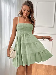 Vue détaillée de la robe d'été verte à volants montrant le tissu texturé et le bustier smocké.