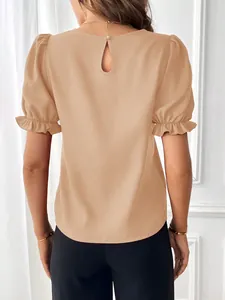 Vista posteriore di una camicetta beige con maniche a sbuffo e apertura a goccia sul retro.