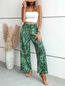 Dettaglio dei pantaloni a gamba larga con stampa paisley verde e vita elasticizzata