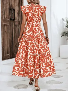 Vista trasera de un elegante vestido de verano con estampado de hojas naranjas y volantes