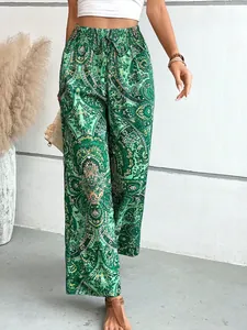 Vista dettagliata dei pantaloni larghi con stampa paisley verde e coulisse elastica