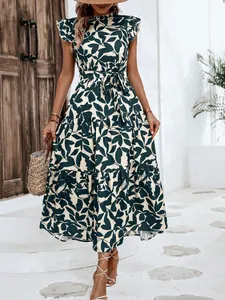 Vestido largo de flores con volantes, mangas mariposa y cinturón en ambiente exterior.