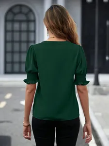 Vista posteriore dettagliata di una camicetta verde scuro con maniche a sbuffo corte e arricciate