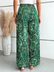 Vista posteriore dettagliata di pantaloni larghi da donna con stampa paisley verde.