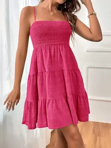 Vue détaillée d'une robe d'été rose fuchsia à fines bretelles et tissu texturé sur modèle.