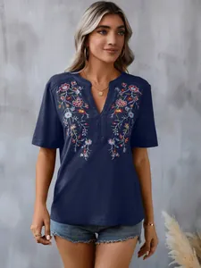 Detailed view of a navy blue top featuring floral embroidery and lace trim neckline