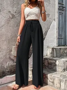 Close-up detail of women's black seersucker wide-leg pants with high drawstring waist