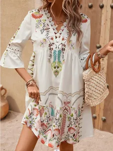 Detail shot of white boho floral mini dress featuring V-neck and lace crochet embroidery.