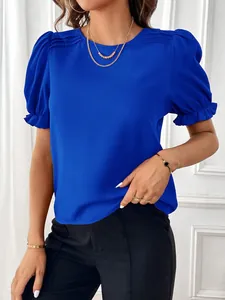Dettaglio di una camicetta blu a girocollo con eleganti maniche a sbuffo pieghettate