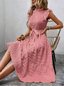 Close-up of pink textured midi dress featuring ruffled cap sleeves and tie-waist.
