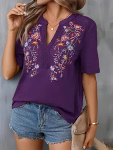 Close-up detail of women's purple summer V-neck top with intricate floral embroidery and lace