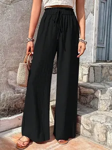 Detail of black wide-leg bubble textured trousers with a high-waisted drawstring design
