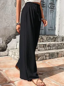 Detailed view of black seersucker wide-leg pants with elastic drawstring waist.