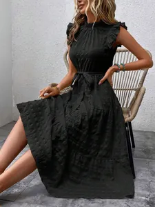 Detailed view of women's black tiered dress with ruffle sleeves and textured tie waist
