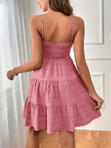 Détail de la vue arrière d'une robe d'été rose texturée avec de fines bretelles spaghetti.