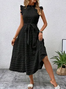 Close-up of black ruffle sleeve textured dress with waist tie and tiered skirt