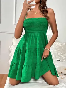 Vue détaillée du corsage smocké vert et de la jupe à volants texturée de la robe