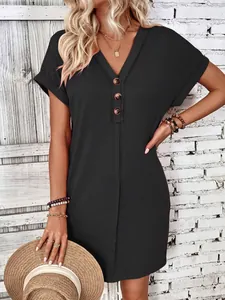 Close-up of a women's dark grey V-neck dress with button details and rolled sleeves.
