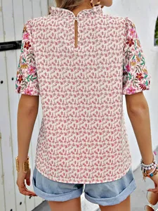 Vue détaillée d'une blouse d'été à imprimé floral avec manches brodées et col montant à volants