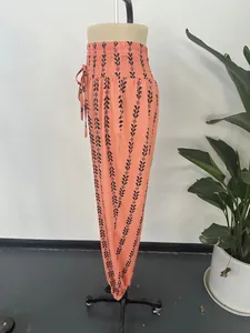 Side view of peach geometric print lantern pants with high smocked waistline