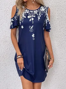 Close-up view of navy blue dress featuring white floral print and cold-shoulder design