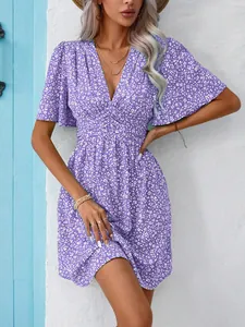 Close-up detail of the V-neck and delicate white floral pattern on a purple summer dress