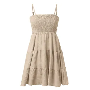 Détail de la robe sans manches à volants avec buste froncé et tissu texturé beige.