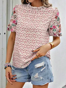 Vue détaillée d'une blouse à fleurs avec manches brodées et col haut volanté pour femme.