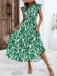 Vista detallada de un vestido largo con estampado de hojas verdes y mangas volantes