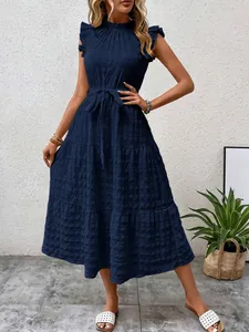 Detailed view of navy blue textured summer dress with ruffle sleeves and tie-waist.